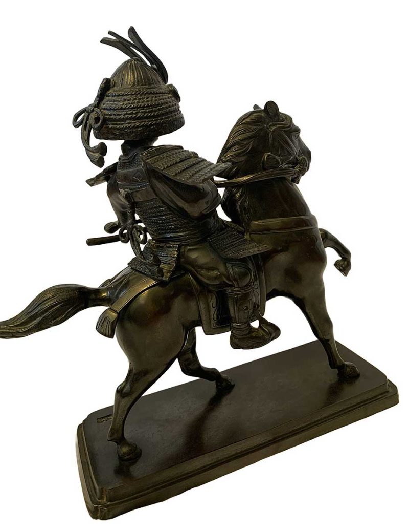 A bronze Samurai on horseback by Syuzan a Handcast Contemporary figure made for GUMP's in Japan by Sento Doki. The Sculpture depicts a medival Japanese warrior in full battle armor astride a prancing mount